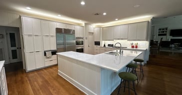 Modern San Antonio kitchen remodel with white cabinets, marble countertops, stainless steel appliances, and spacious island