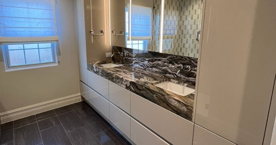 Modern San Antonio bathroom remodel with double sinks and bold marble vanity by Wade Caldwell Construction