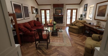 Cozy living room remodel in San Antonio with herringbone wood floors and French doors by Wade Caldwell Construction