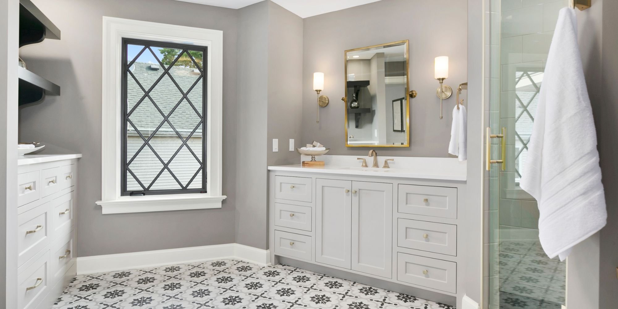 Sophisticated Wade Caldwell bathroom design in San Antonio showcasing custom vanity, gold hardware, and decorative floo