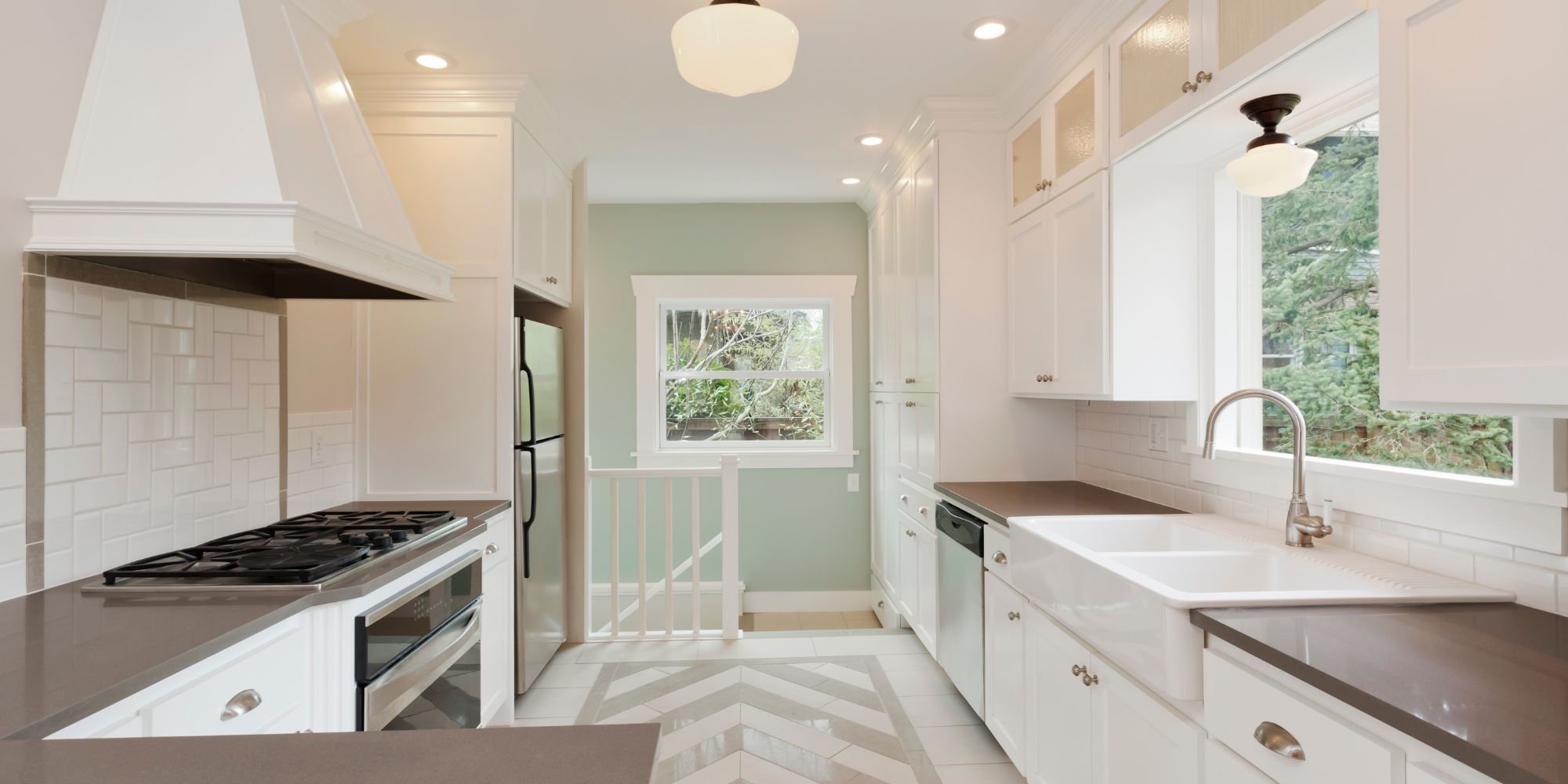 Bright San Antonio kitchen renovation by Wade Caldwell featuring farmhouse sink and chevron tile fl