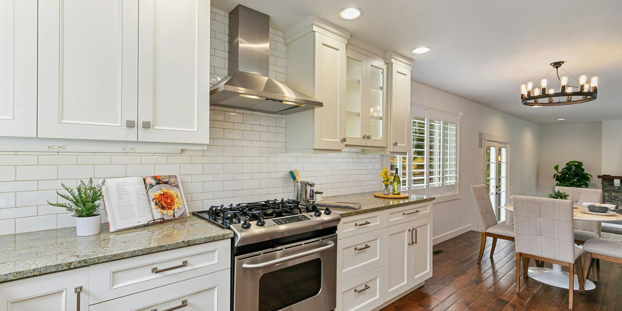 Bright San Antonio kitchen remodel by Wade Caldwell featuring white shaker cabinets, granite countertops, and stainl