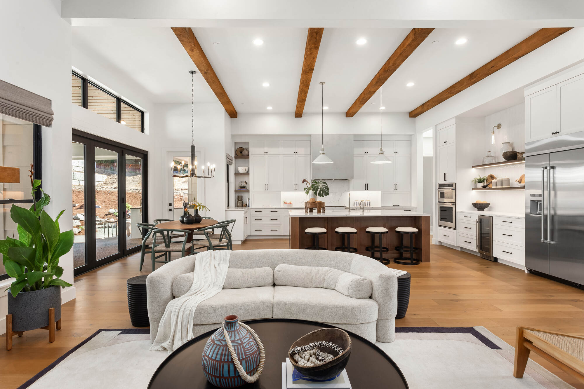 Open kitchen renovation with wood beams and white cabinetry by Wade Caldwell Construction in Castle Hills, TX