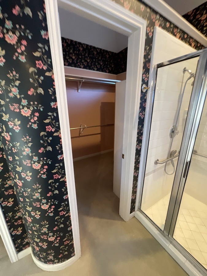 Updated bathroom layout in San Antonio featuring closet access and floral w