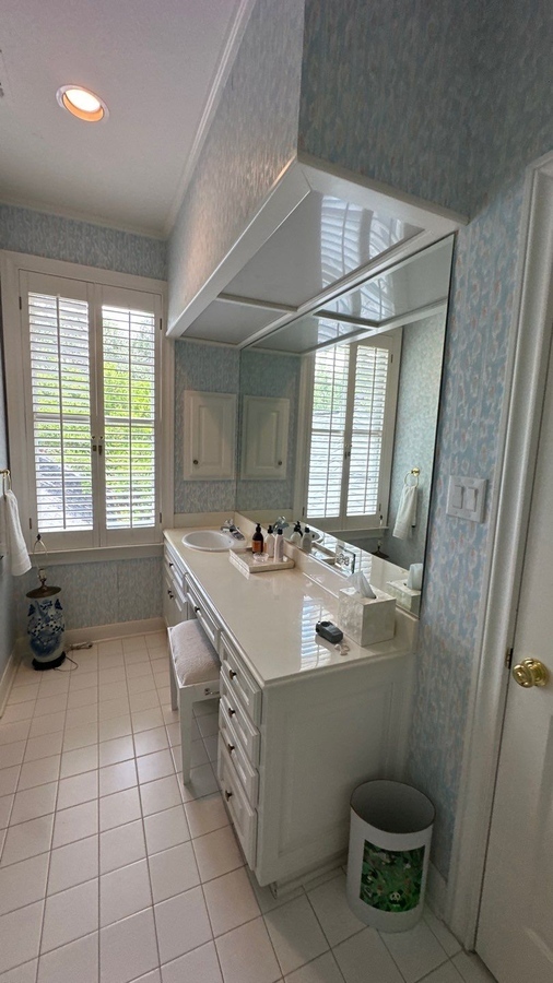 Classic white bathroom renovation with wall-to-wall mirror and natural light in San An