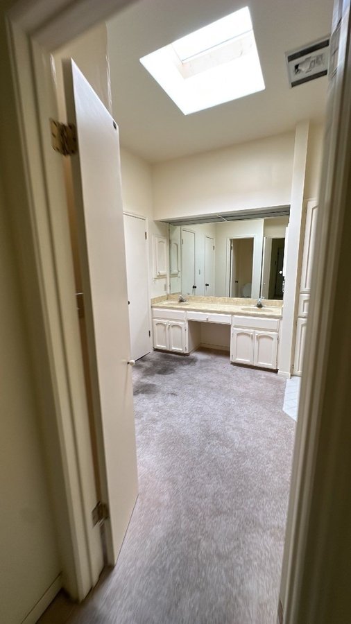 Spacious vanity with dual sinks and skylight lighting in Castle Hills, TX bathroom remodel by 