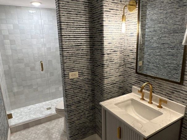 Bathroom remodel by Wade Caldwell Construction featuring modern tile walls and gold fixtures Bathroom remodel by Wade Caldwell Construction featuring modern tile walls and gold fixtures