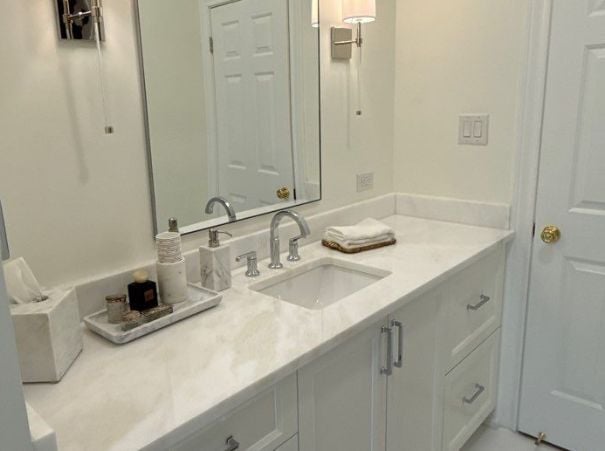 Modern white bathroom vanity with chrome fixtures remodeled by Wade Caldwell Construction in Alamo Heights, TX