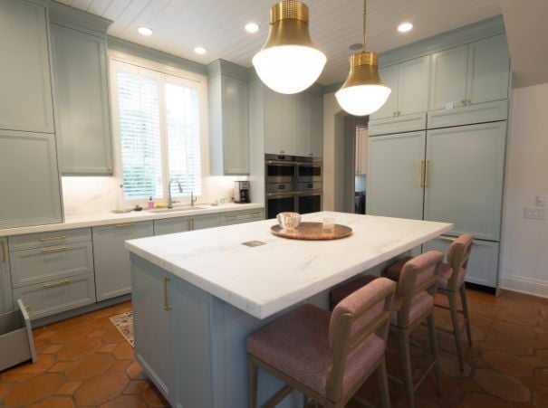Soft green kitchen remodel with marble island and brass lighting by Wade Caldwell Construction in Olmos Park, TX