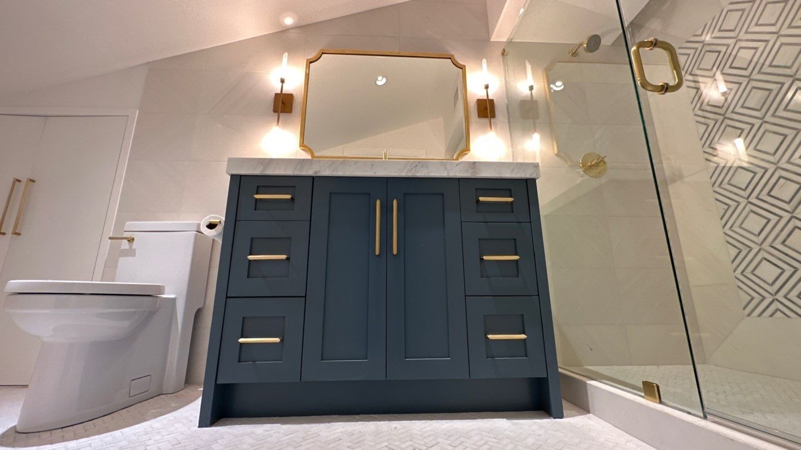 Sophisticated bathroom design with blue cabinets and gold