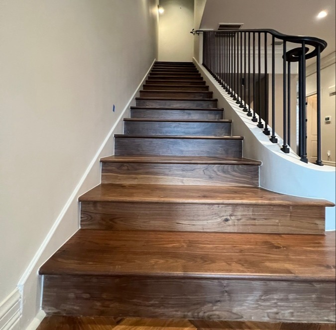Staircase remodel with wood treads and iron railing by Wade Caldwell Construction in S
