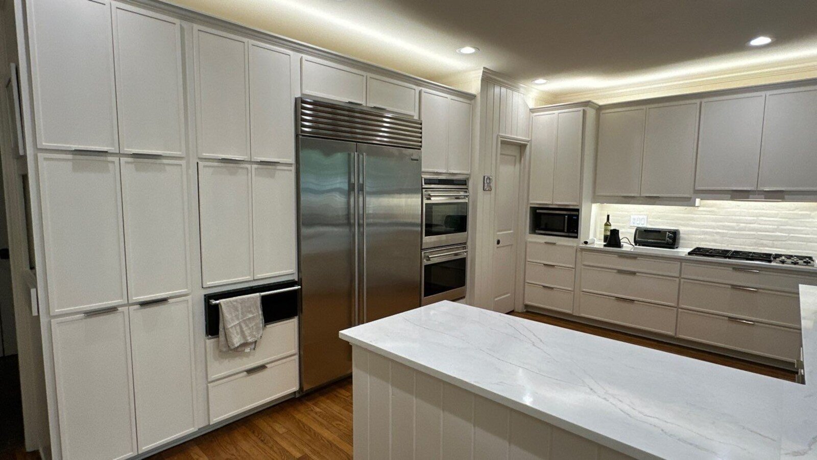 Sleek custom kitchen renovation in San Antonio featuring double ovens and floor-to-ceiling